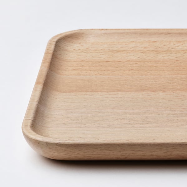 Wooden dish, smooth and polished, diagonally placed on white surface, showcasing its natural, light brown finish.