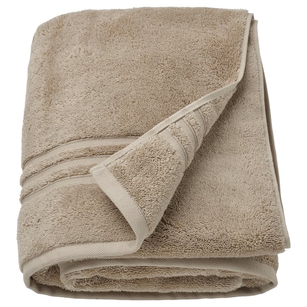 BROKGLIM organic cotton towels, beige, piles of folded, textured terry cloth with woven border.