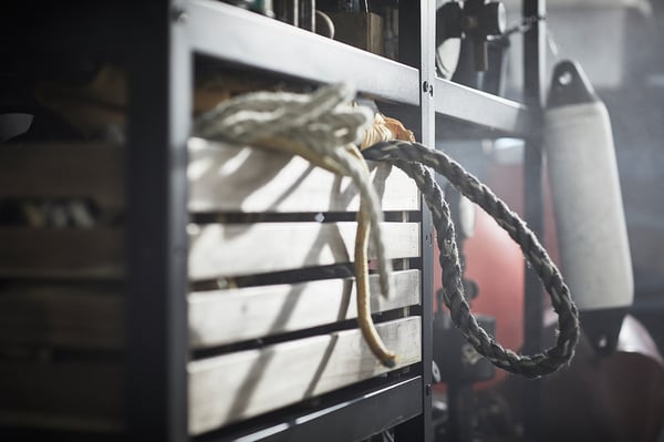 Close-up of BROR, gray shelf, metal, industrial design, with ropes.