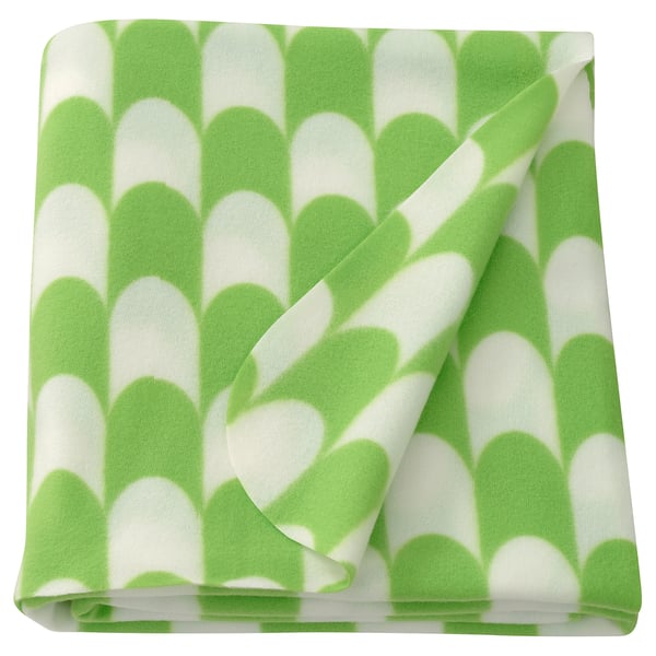 Folded lime green & white patterned throw blanket, scalloped design, soft polyester.
