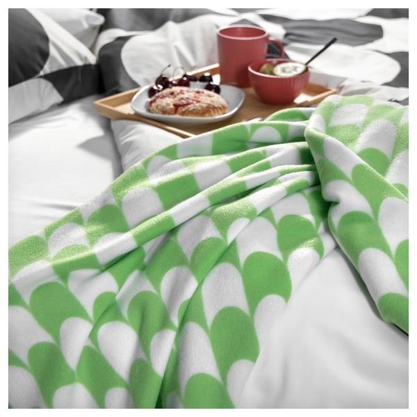 Modern green & white throw blanket on bed - 34 characters