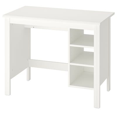 A white BRUSALI desk with a rectangular top, adjustable shelves, and four legs. It has a traditional style with a crafted look.