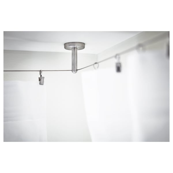 A curtain wire fittings system. It highlights a metal rod and wall-mounted clips, ensuring stability and adjustability.