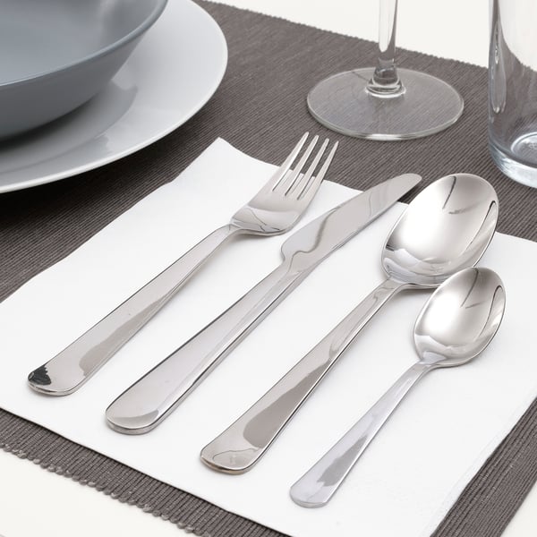 Polished cutlery set on napkin, including fork, knife, and spoons, ready for dining.