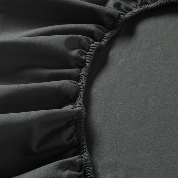 Black fitted sheet with elastic edges, showcasing soft cotton texture and durable quality.