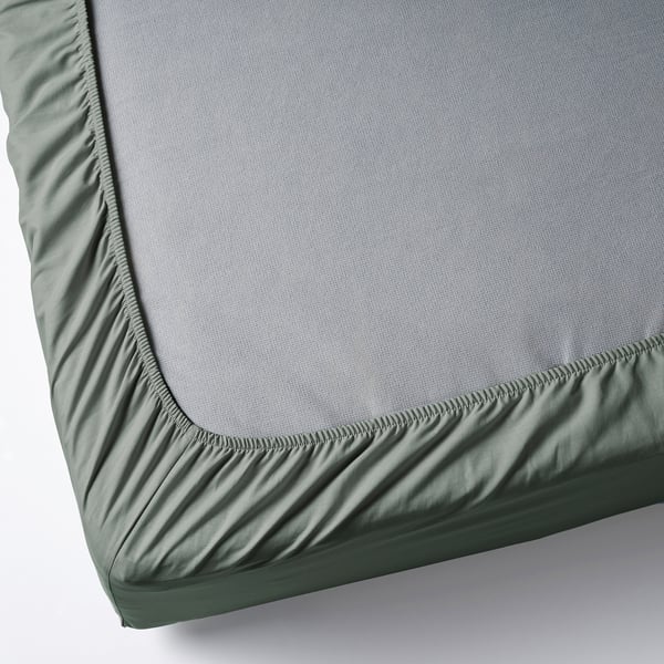 Gray-green fitted sheet corner with grey mattress. Elastic edging ensures a secure fit.