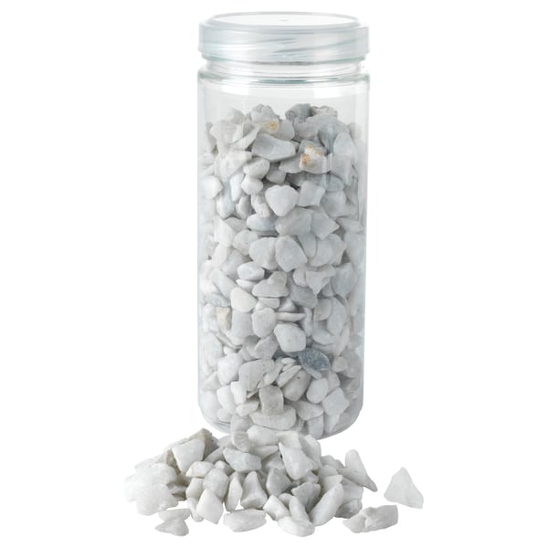 Jar of white stones, some spilled.