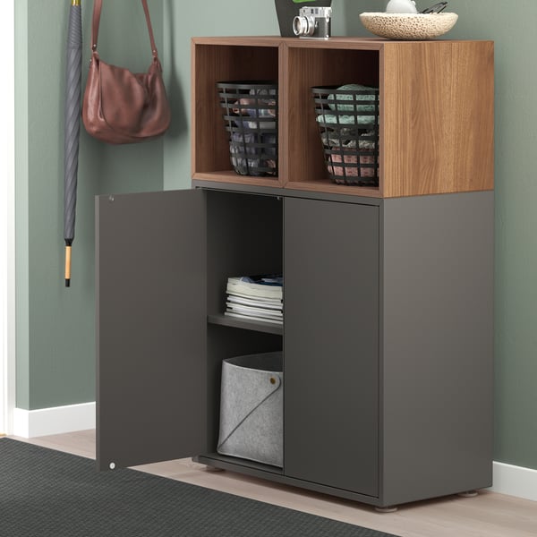 Modern storage unit with open and closed compartments. One door open, revealing shelves with items like books and bins.