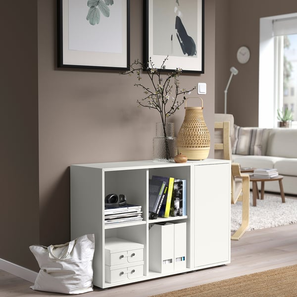 EKET white storage combo. Small, light wood, modern design. Holds books, vases. Sits below frames.
