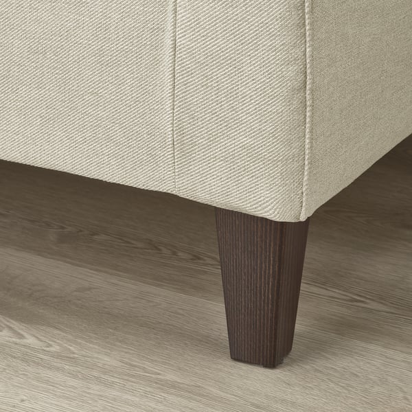 A modern sofa with tapered wooden legs and upholstered textured fabric.