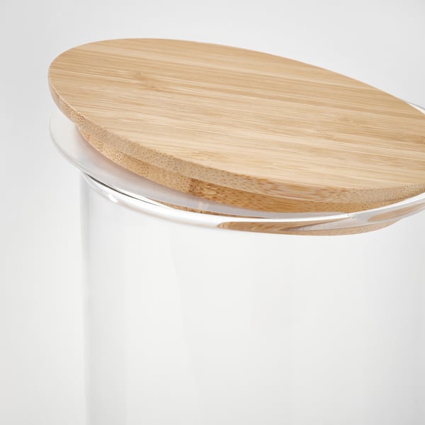 Close-up of stylish glass jar with wooden lid, showcasing quality materials and design.