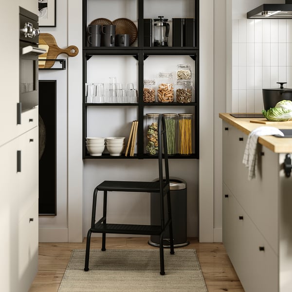Modern kitchen with open shelves, organised food, and a step stool.
