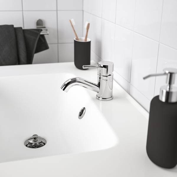 Modern bathroom: chrome tap, black soap dispenser.