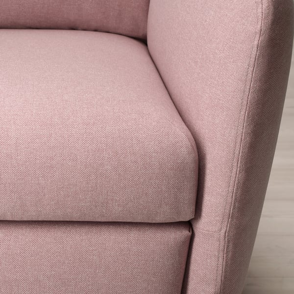 Close-up of a soft, pink fabric chair with rounded armrests and cushioned seat, emphasising comfort and quality.