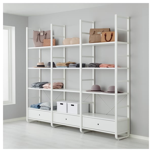 White ELVARLI storage system with shelves and drawers, displaying handbags, hats, and folded clothes, mounted to wall.