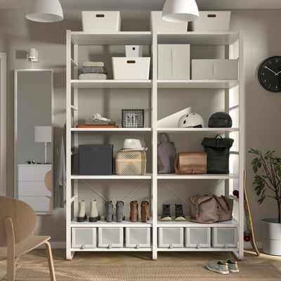 White ELVARLI storage unit with shelves holding bags, boots, helmets, and boxes. Wall-mounted, offers versatile open storage.