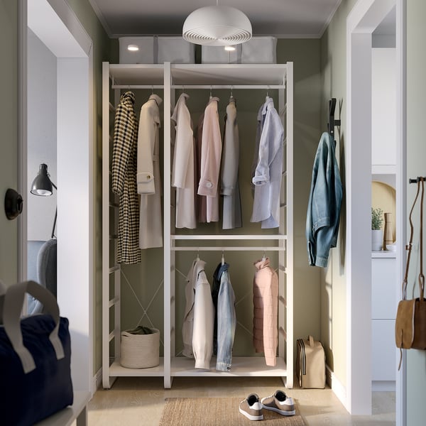 Modern closet with adjustable rails, shelves, and hooks, holding garments and accessories.