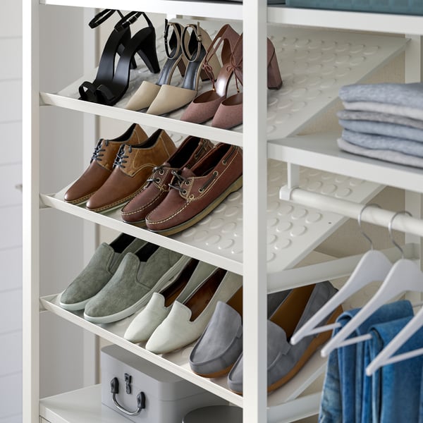 White closet shelves storing various shoes. Brown loafers, green slip-ons, and blue trainers visible. Drawers and hanging clothes also seen.