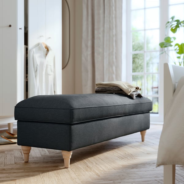 Modern grey fabric bench with wooden legs, soft cushioned seat, elegant design, and hidden storage.