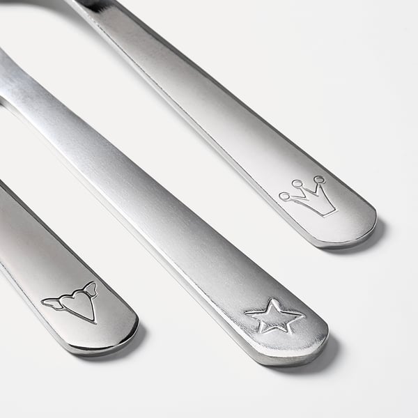 Three stainless steel childrens utensils: knife, fork, spoon, each with unique engraved designs.