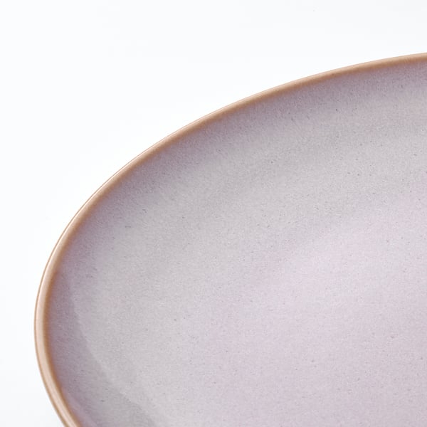 Close-up view of a simple, rustic, greyish plate with a smooth surface, placed on a white background.