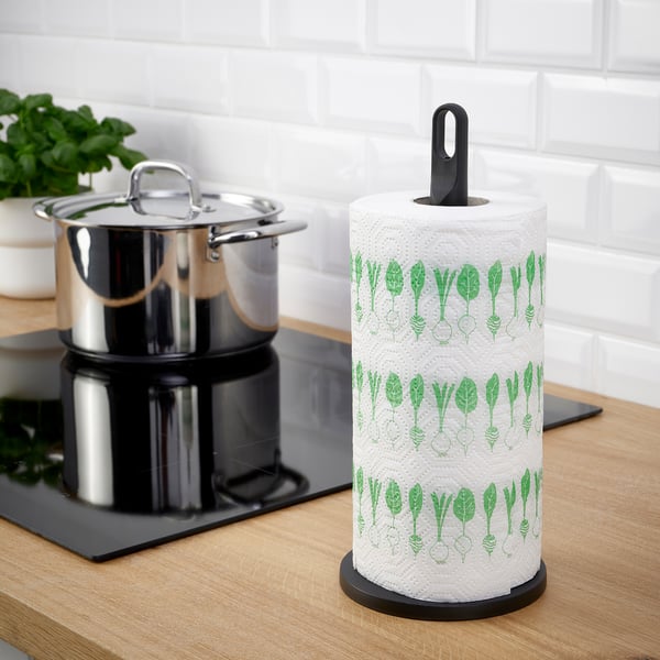 Roll holder on counter, designed with a carry loop, holds patterned paper roll.