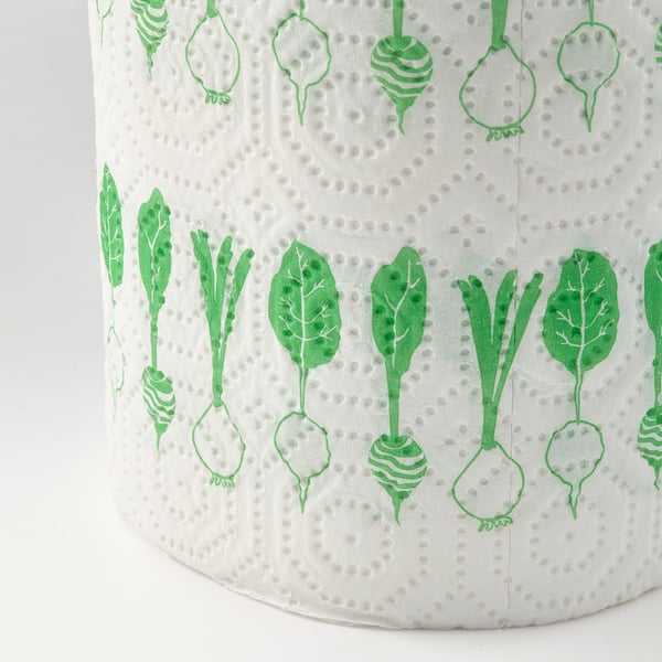 Roll of kitchen paper with green veggie patterns, highly absorbent, made from recycled materials.