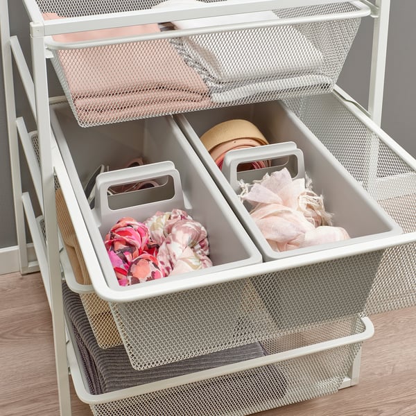 Metal storage unit with mesh baskets holding folded clothes in compartments.