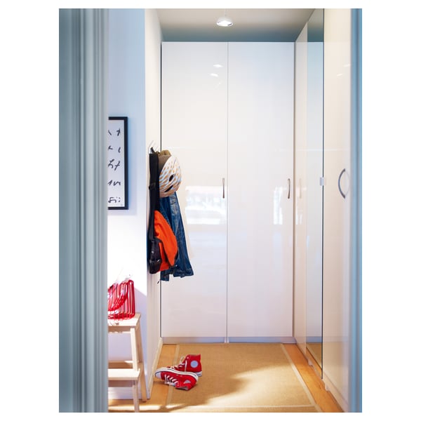 Neat hallway with white FARDAL wardrobe, hanging coats, and red trainers on rug.