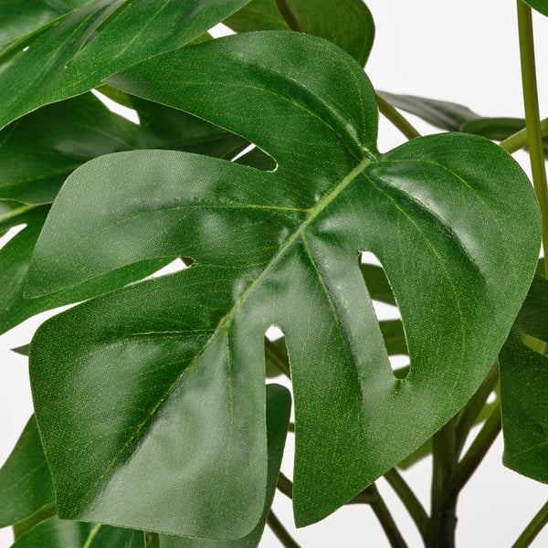 Large green leafy plant, lifelike and lush, vibrant and detailed, realistic artificial foliage.