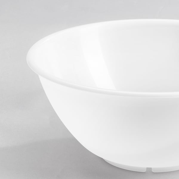A crisp, white, seamless plastic bowl sits on a light surface; minimalist design.