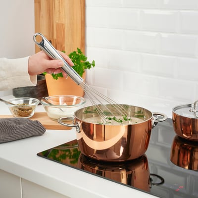 Person using FINMAT whisk with curved handle