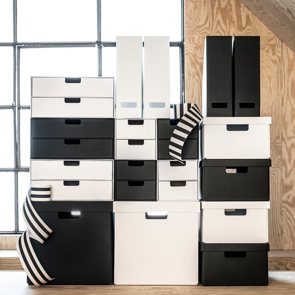 Black & white storage boxes, various sizes, stacked. Modern, minimalist design. Made of recycled paper.