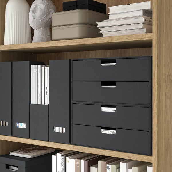Wooden shelves with grey fabric drawers and white books.