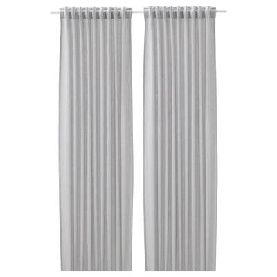 Two light-colored curtains hang side by side, featuring simple, pleated designs for privacy and light control.