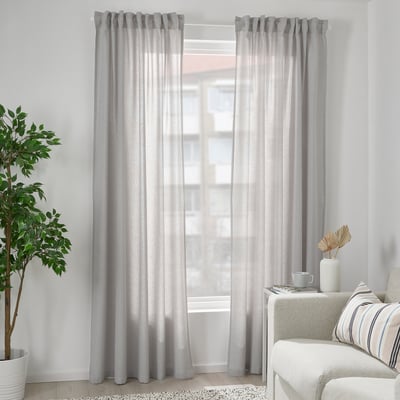 Azure FJÄDERMOTT curtains, light grey, cotton, flowing, window covering, flanking window, white couch, plant, natural light.