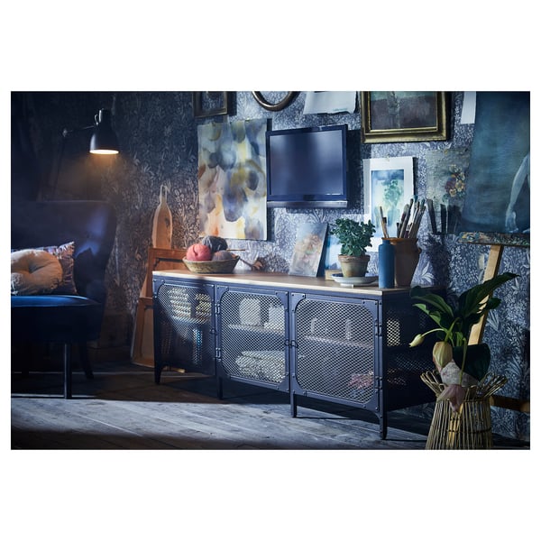 Modern living room with wooden floor, dark blue wallpaper, sleek tv stand, cushioned chair, wall art, and decorative plants.