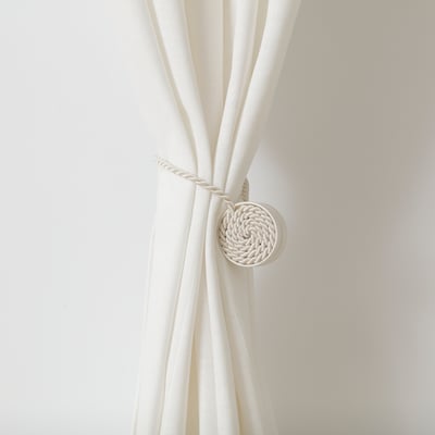 White rope-like curtain tie-back with magnetic ends. Easily keeps curtains open without damaging walls.