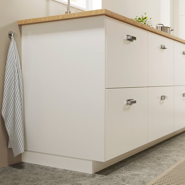 Modern kitchen cabinets, FÖRBÄTTRA white, with wooden countertop, metallic handles, striped towel hanging.