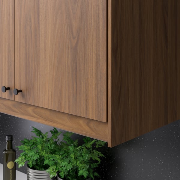 Dark-handled wooden cabinets with plant and bottle.