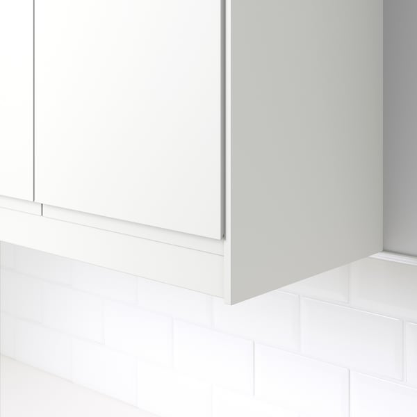 White corner moulding on tiled wall, hiding lighting units and cords under cabinets.
