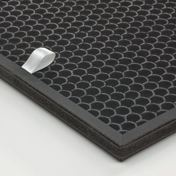 Black honeycomb-patterned charcoal philtre for gas cleaning, bordered by durable black plastic, laid on a white surface.