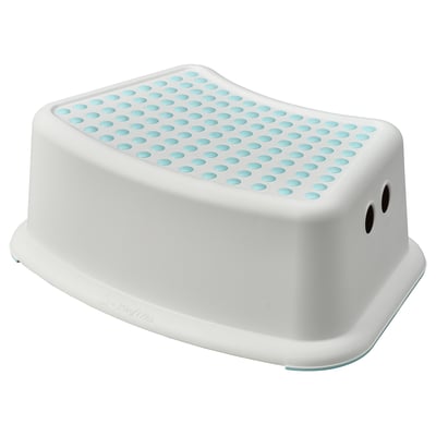 A white FÖRSIKTIG step stool with blue, non-slip dots on top. Its square-shaped with rounded edges and two small holes on the side for carrying.