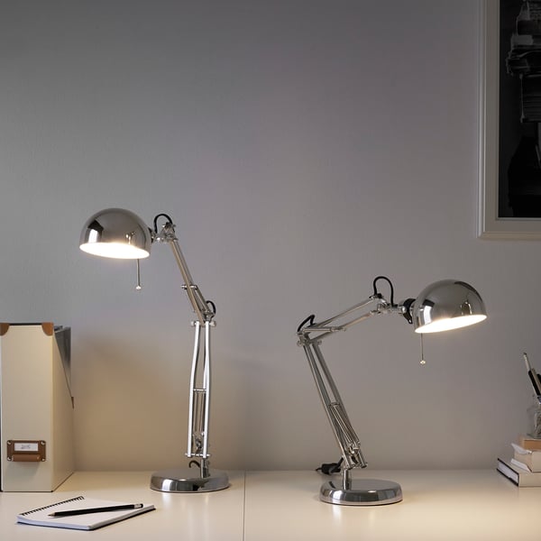 Two FORSÅ lamps on desk, one taller, both adjustable. Modern classic design.