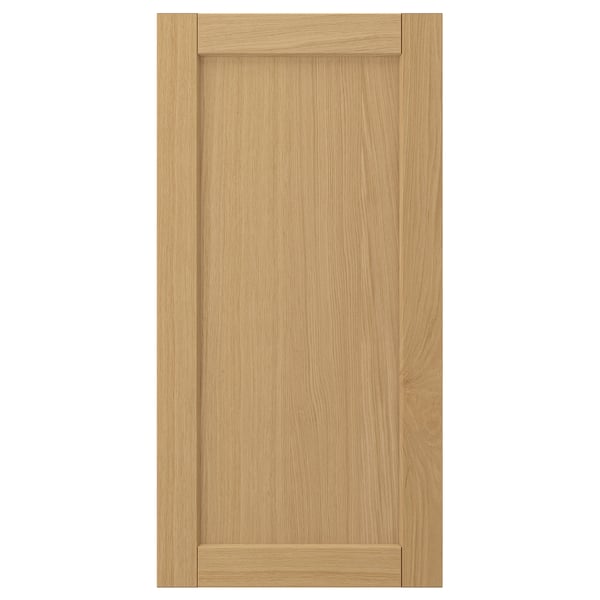 A FORSBACKA cabinet door in warm oak veneer featuring a classic, framed design with bevelled edges.