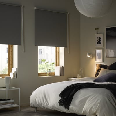 Bedroom with dark grey FRIDANS blinds, white bed, black throw.