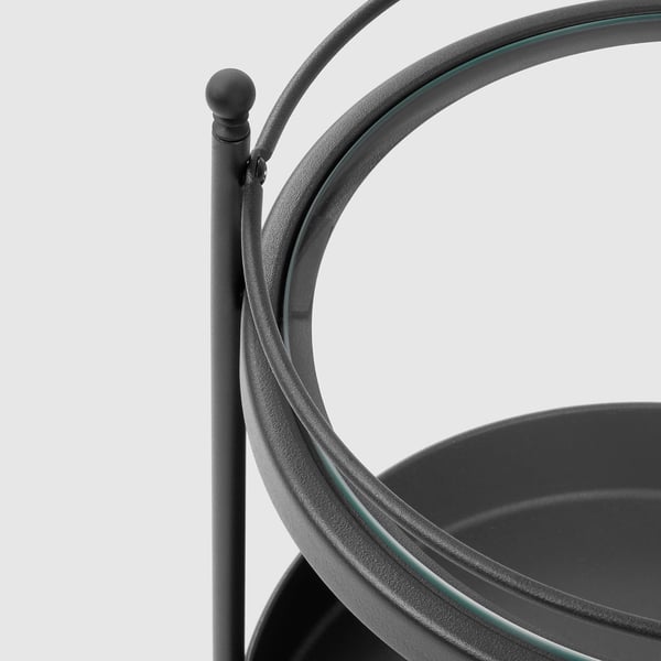 Black metal bathroom trolley with curved handle and glass shelf.