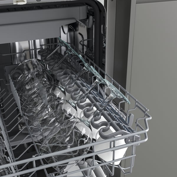 Dishwasher rack with plates and cutlery, showing space-efficient design.