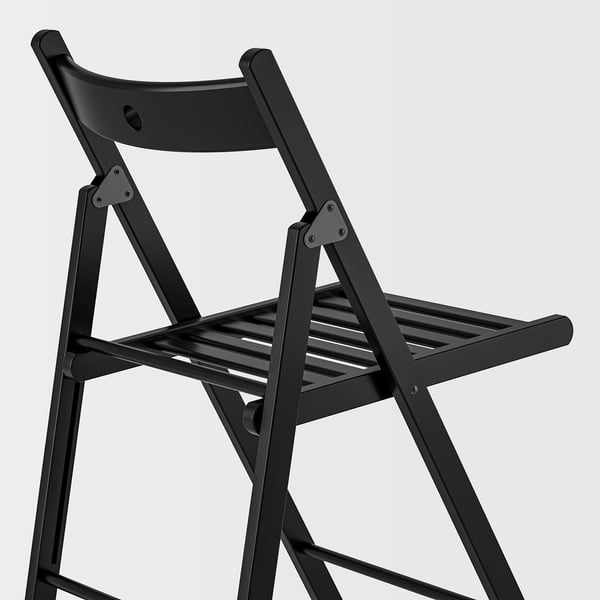 Black folding chair with metal hinges, sturdy design, angled view.
