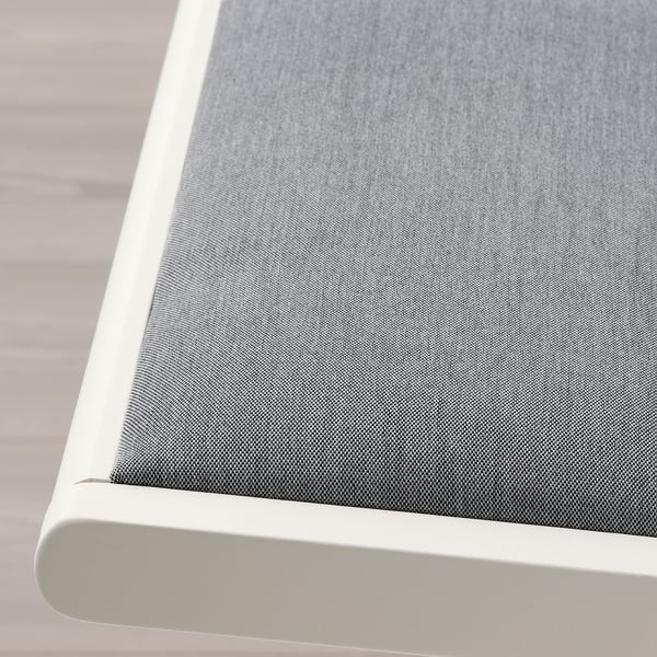 Close-up view of a modern, upholstered chair in neutral tones, emphasising its sleek design and durable fabric.